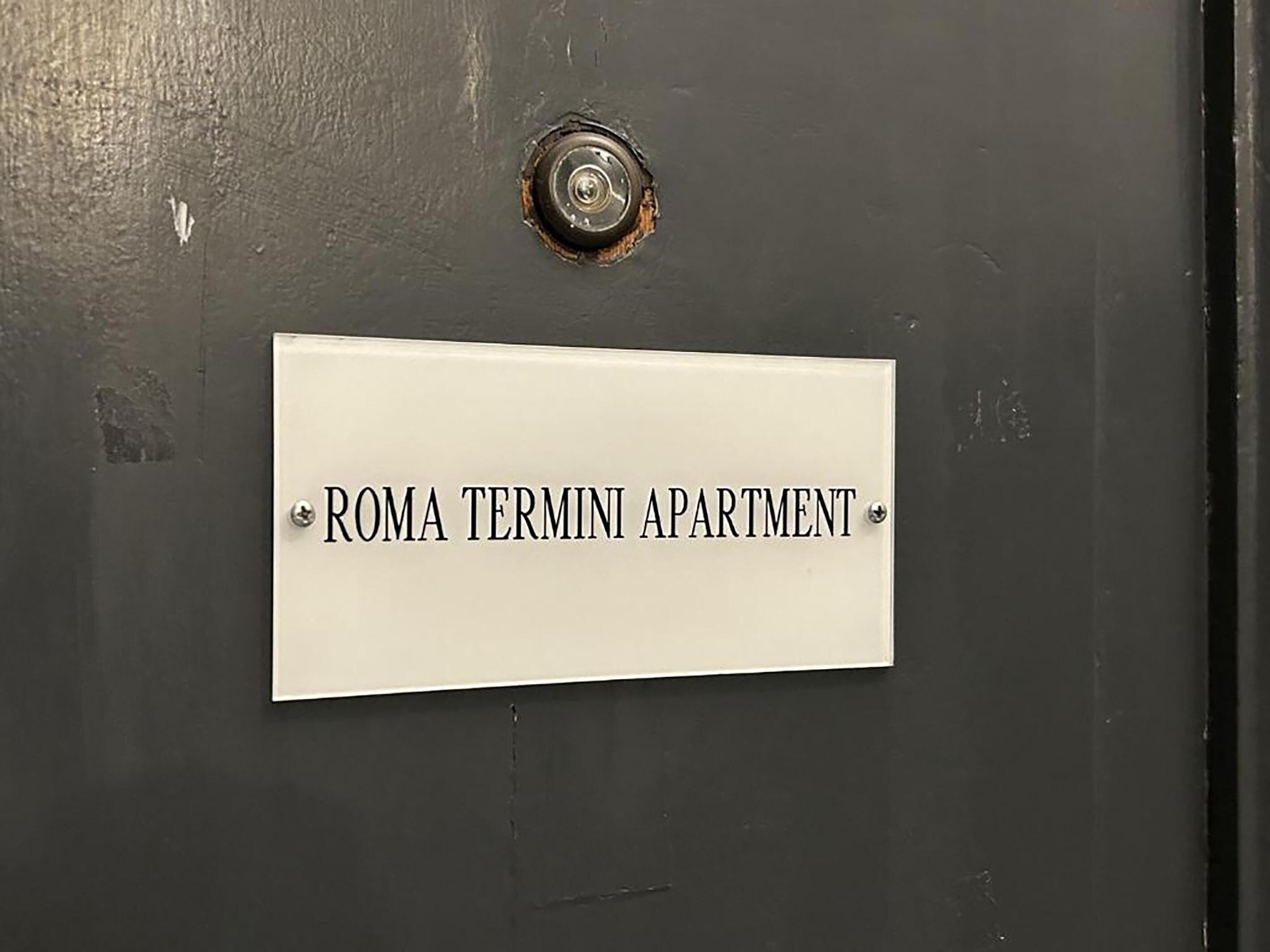 A door with a sign that reads "ROMA TERMINI APARTMENT".