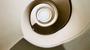 A spiral staircase with a central light fixture. - Tiziano House by Ghor (Rome)