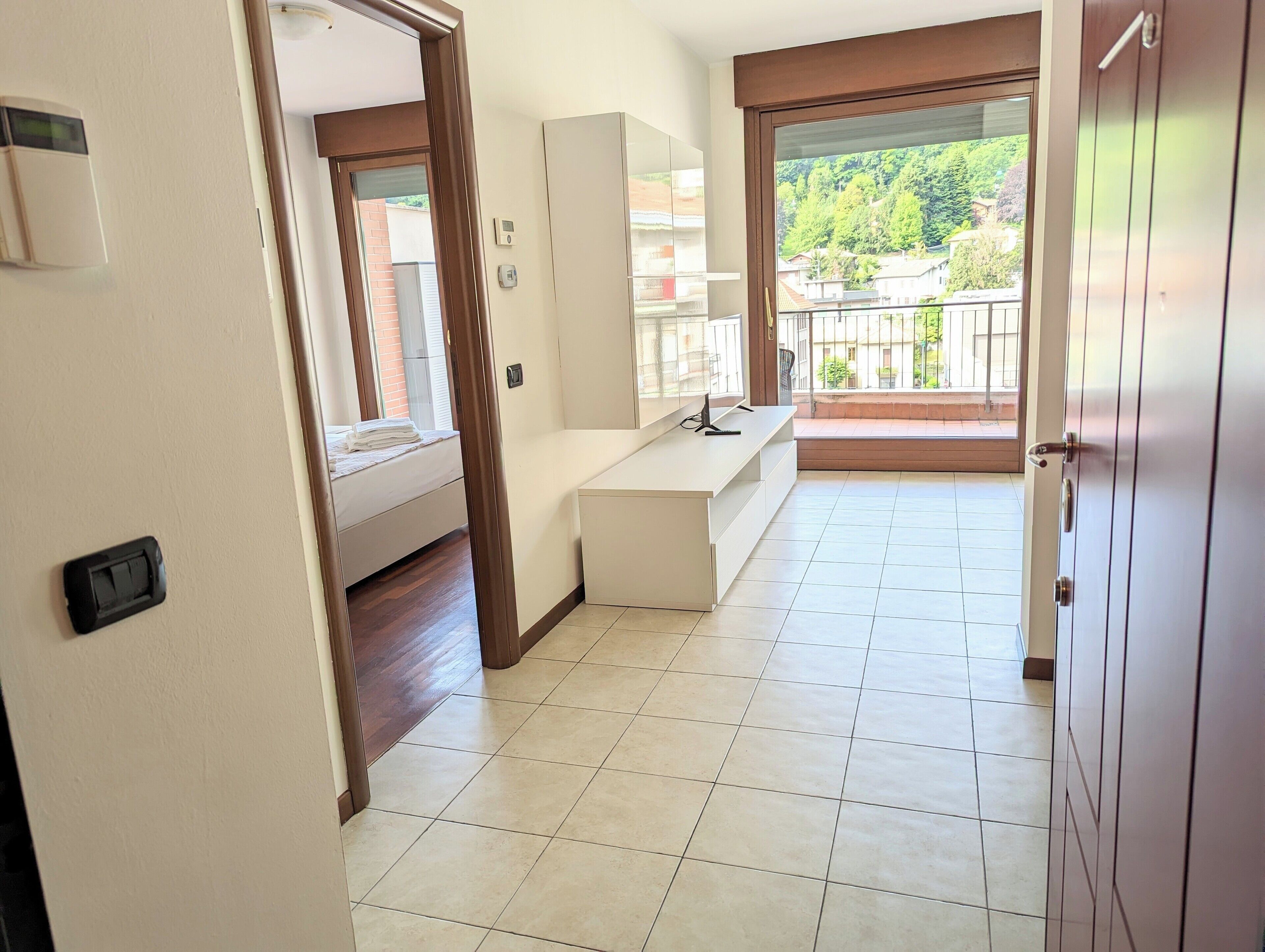 Een hotelkamer met balkon, een bed, bureau en groot raam.