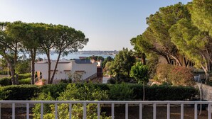 Una propiedad costera con un edificio blanco, un muro de piedra y vistas al mar.