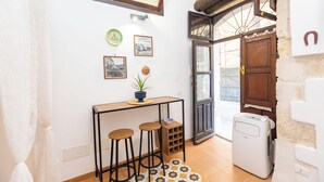 Una piccola cucina con tavolo, sgabelli, frigorifero e una finestra vista.