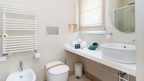 A modern bathroom with a white sink, a mirror, a towel rack, and a toilet. - Marina Homes Deluxe Sea View 2 Ortigiapartments (Syracuse)