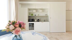 A modern kitchen with white cabinets, a microwave, a coffee maker, and a refrigerator. - Marina Homes Deluxe Sea View 2 Ortigiapartments (Syracuse)