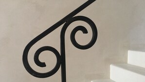 A staircase with a black metal handrail and white steps. - Terrazza Cavalieri di Malta by Ortigiapartments (Syracuse)