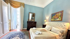Un dormitorio con una cama grande, un aparador, un espejo y un cuadro en la pared.