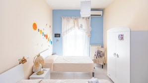 A bedroom with a bed, bedside table, wardrobe, and a window with curtains. - Poseidone Apartment - Two Bedroom Apartment, Sleeps 4 (Syracuse)