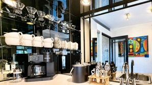 Una cocina moderna con una isla grande, cafeteras y una variedad de utensilios de cocina.