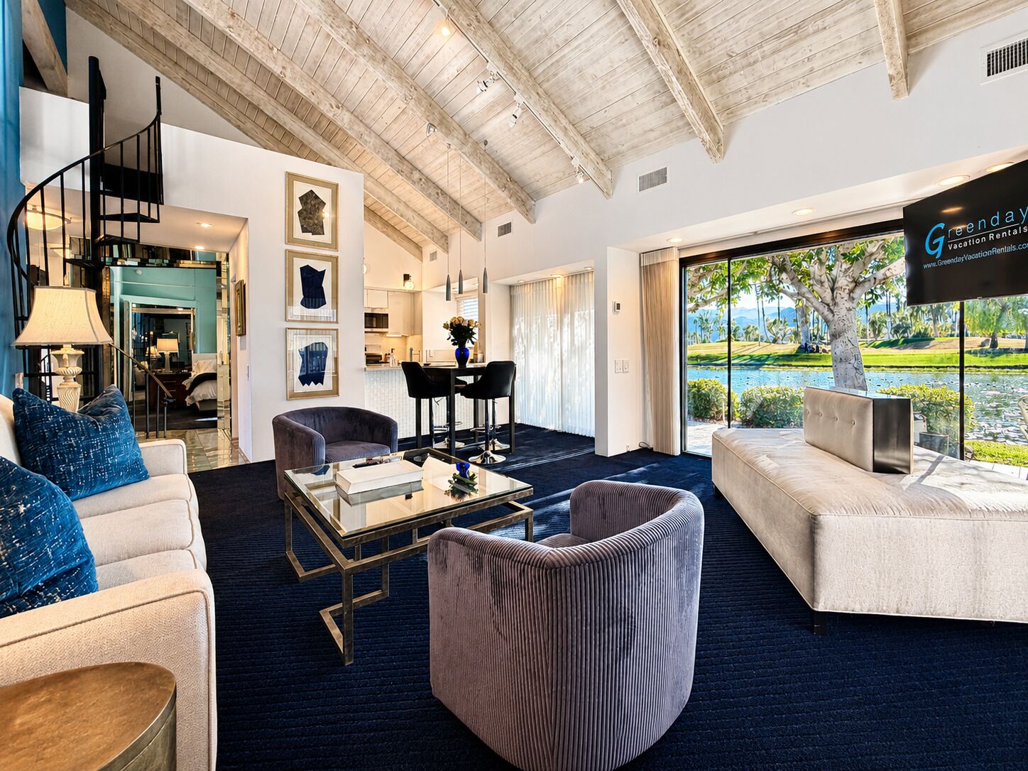 A modern living room with a high ceiling, a dining area, and a view of a landscaped garden.