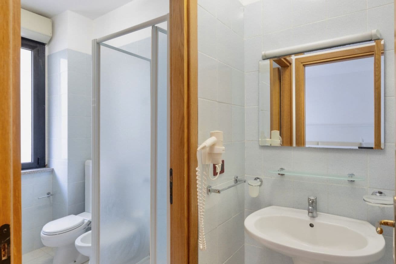 A bathroom with a toilet, a sink, and a glass shower enclosure.