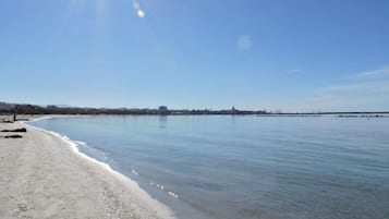 Une plage à l’eau claire, avec une côte qui s’étend au loin.