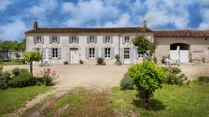 A large, two-story building with a courtyard, featuring a traditional architectural style with a tiled roof and shuttered windows. - Holiday Home “La Longère Claudine” with Shared Pool, Terrace & Wi-Fi (Fontenet)