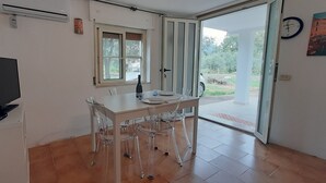 A small kitchen with a dining table and chairs, a TV, and a window. - Vacation home 200 mt from the sea in sardinia (Tertenia)