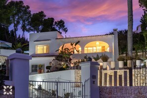 A modern two-story house with a stone facade, a balcony, and a well-maintained garden. - Villa ONA MAR by Abahana Villas (Teulada)