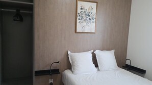 A hotel room with a bed, white pillows, a nightstand, a wall-mounted painting, and a wardrobe. - 1 Bedroom unit with balcony in front of Le Bourget Airport (Le Blanc-Mesnil)