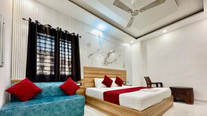 Una camera d'albergo moderna con un letto grande, un divano blu e un tavolino.