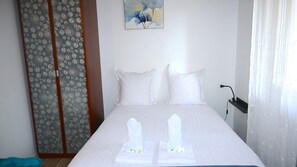 A neatly made bed with white linens and two towels placed on the bed. - Studio unit with balcony in front of Le Bourget airport (Le Blanc-Mesnil)