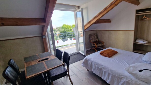 A bedroom with a bed, a desk, and a chair. There is a wardrobe and a window with a view of the outside. - Le 60 - ODI RENT - In front of Le Bourget AIRPORT (Le Blanc-Mesnil)