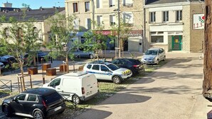 A parking area with several cars and a building with a green door in the background.