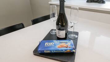 A table with a bottle of Morajio Prosecco, two wine glasses, and a package of Vienna Milk Chocolate.