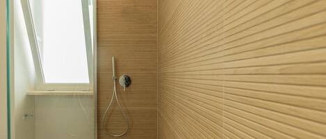 Une douche avec une porte en verre, une fenêtre et un mur en bois.