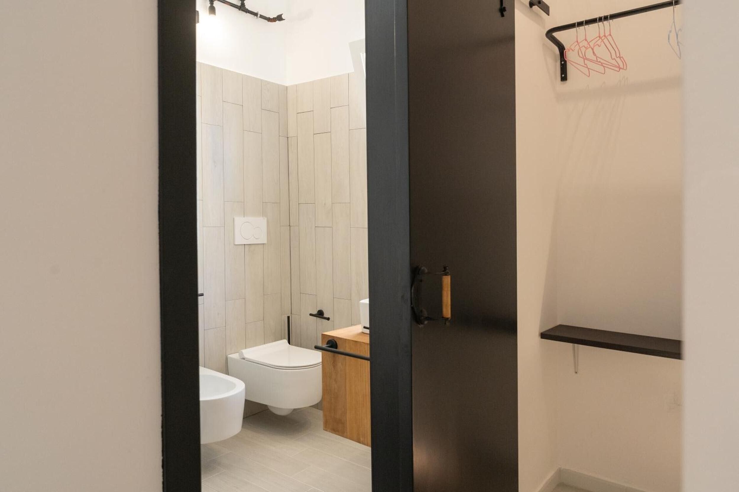 Un baño moderno con inodoro, lavabo y zona de ducha.