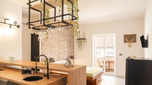 Une cuisine moderne avec un plan de travail en bois, un mur en briques et une plante suspendue.