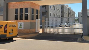A gated entrance to a residential building with a yellow delivery van parked in front.