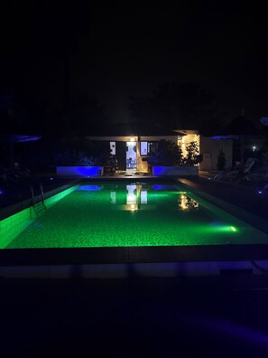 Alberca al aire libre, sombrillas en la alberca y camastros 