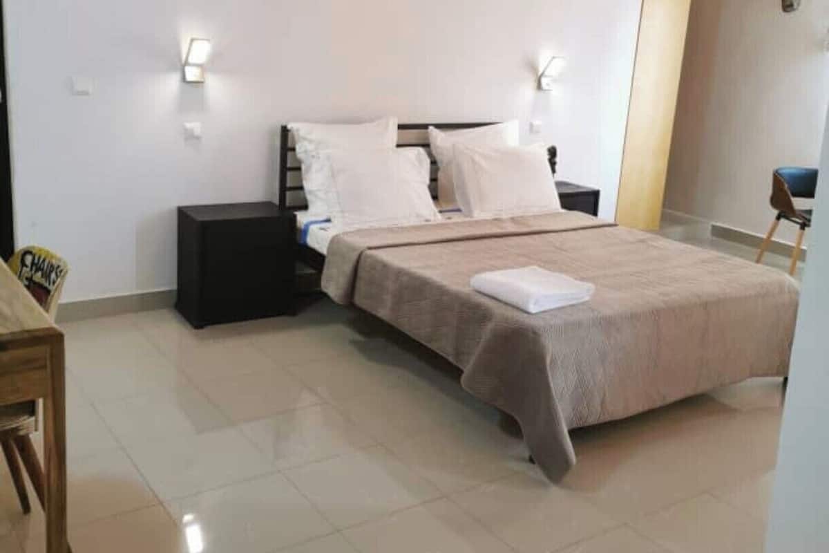 A bedroom with a bed, nightstands, a chair, and a small table.