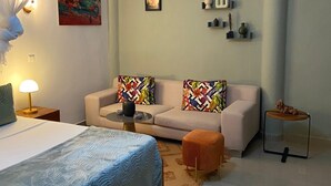 Une chambre moderne avec un lit, un canapé, une petite table et un élément décoratif mural.
