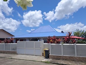 Ein Haus mit blauem Dach, weißen Wänden und einem verschlossenen Eingang.