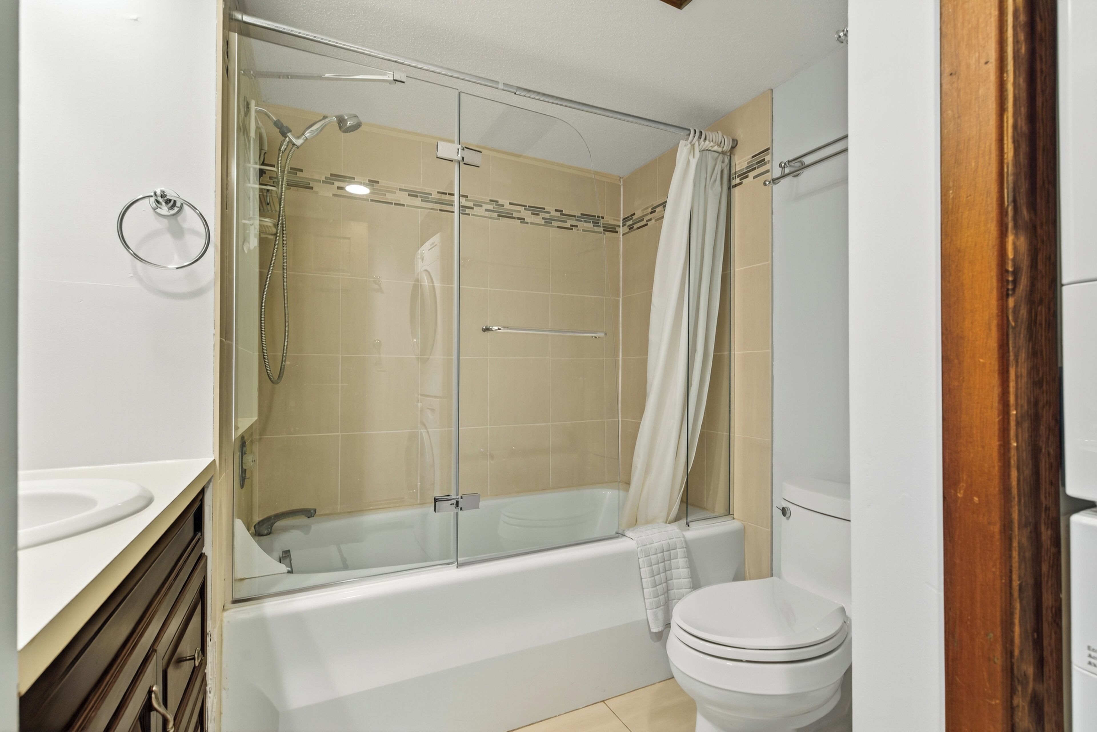A modern bathroom with a glass-enclosed shower, a bathtub, and a toilet.