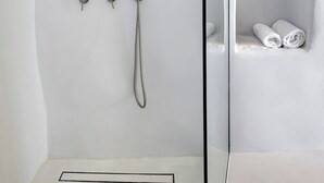 Μια σύγχρονη καμπίνα ντους με αποσπώμενο ακροφύσιο και βρύση τοποθετημένη στον τοίχο.