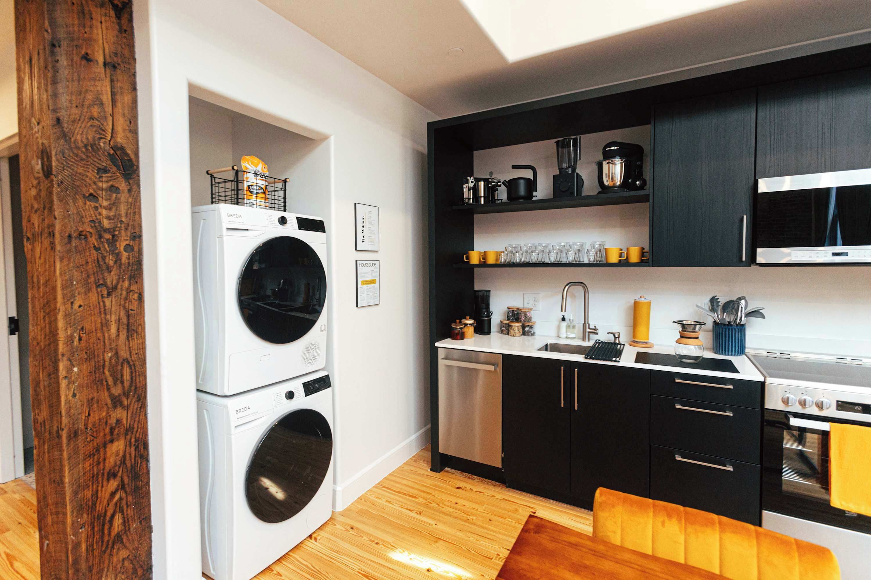 A compact kitchen with a washing machine, a microwave, and a stove.