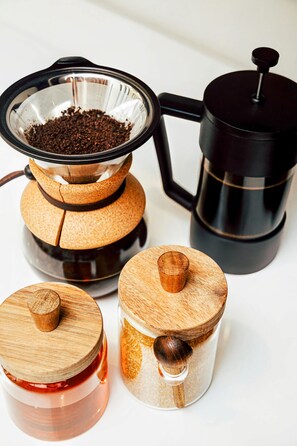 A coffee maker, a glass container with coffee grounds, and two jars with wooden lids. - Loft 308 The William Views Over Carrigan s (Birmingham)