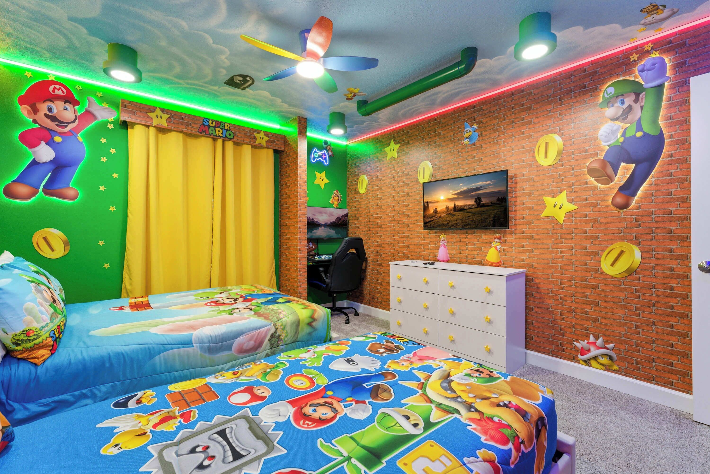 Ein Kinderzimmer mit zwei Betten, einem Schreibtisch und einer Kommode.