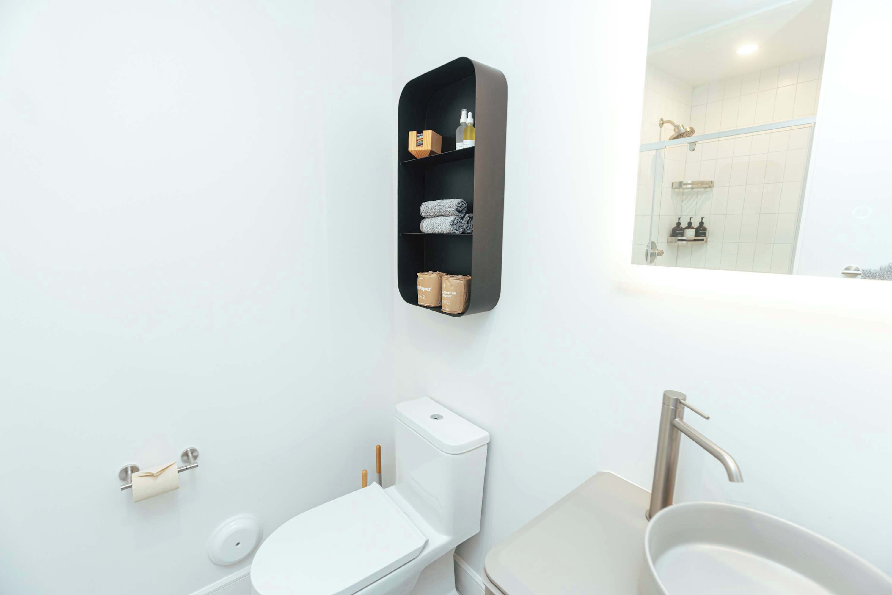 Une salle de bain moderne équipée de toilettes, d’un lavabo et d’une douche.