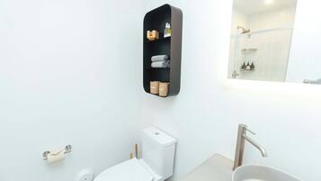 Une salle de bain moderne équipée de toilettes, d’un lavabo et d’une douche.