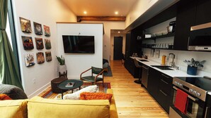 A modern kitchen with black cabinets, a stainless steel oven, and a wooden floor. - Loft 303 - The William - Atrium - Chic - Walkable (Birmingham)
