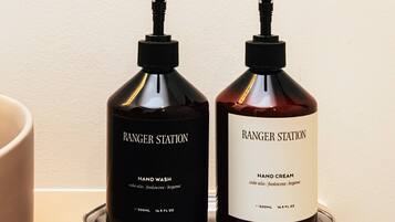 Dos botellas de jabón líquido para manos y crema hidratante Ranger Station sobre una bandeja.