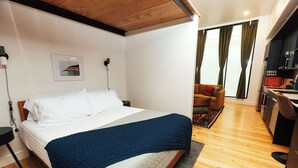 Una camera d'albergo con un letto, una scrivania e vista all'esterno.