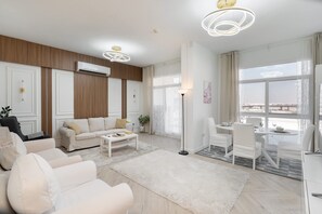Ein modernes Wohnzimmer mit einer Couch, einem Couchtisch und einem Essbereich mit Stühlen und einem Tisch.