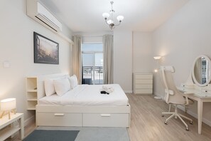 A modern bedroom with a large bed, a desk, and a chair. - Stayshort - Serene 2-bedroom With Relaxing Balcony Atmosphere in Liwan (Dubai)