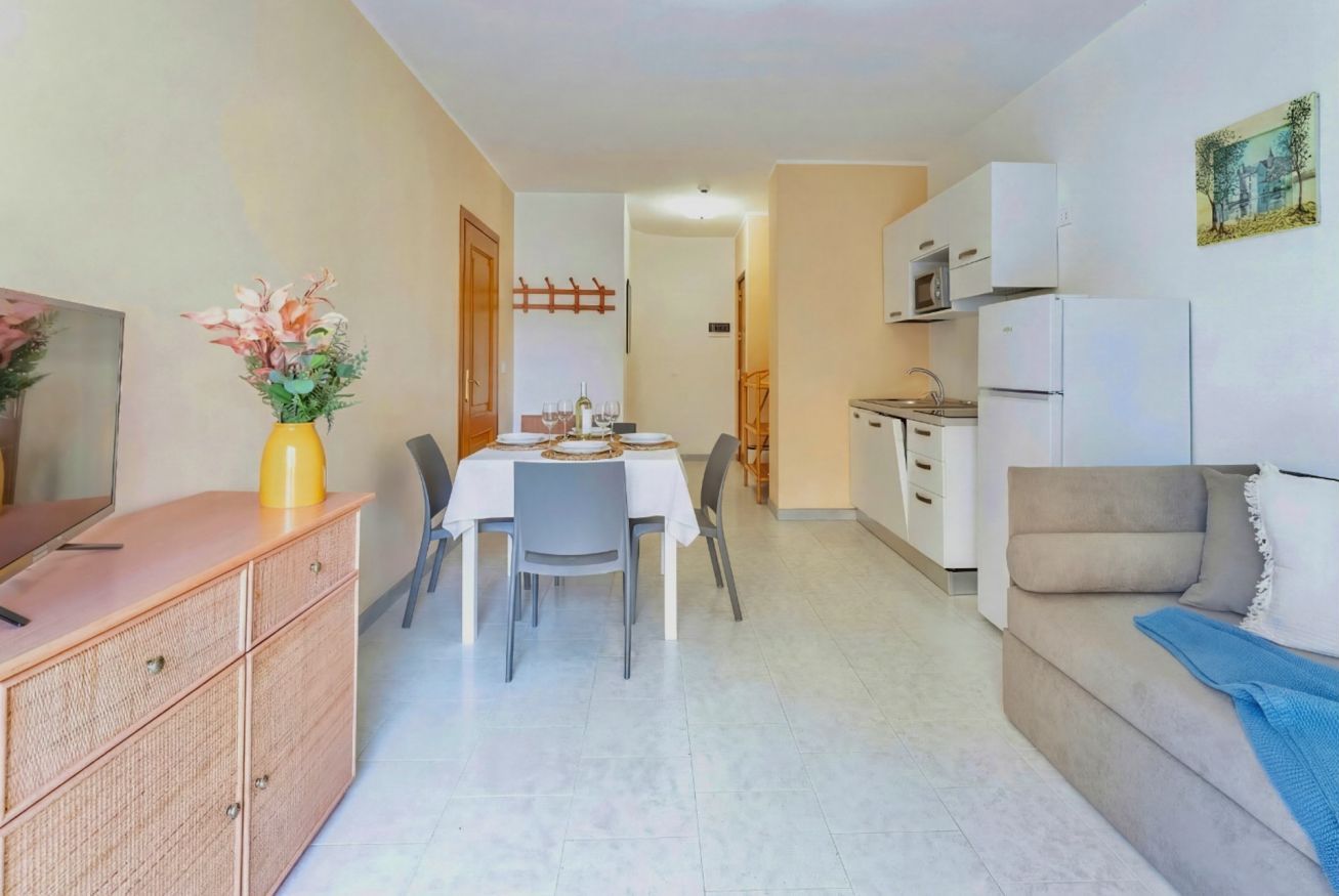 Un espace de vie compact comprenant un coin repas, une kitchenette et un canapé.