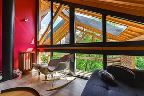 Ein modernes Interieur mit hoher Decke, großen Fenstern und Holzboden.