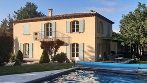 Una casa de dos pisos con una piscina delantera.