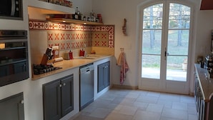 Una cocina con horno empotrado, lavavajillas y un amplio ventanal con vistas al exterior.
