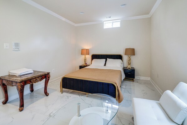 A bedroom with a bed, bedside tables, a glass coffee table, and a white sofa. - Family-friendly Home w/ Foosball in Silver Spring! (Silver Spring)