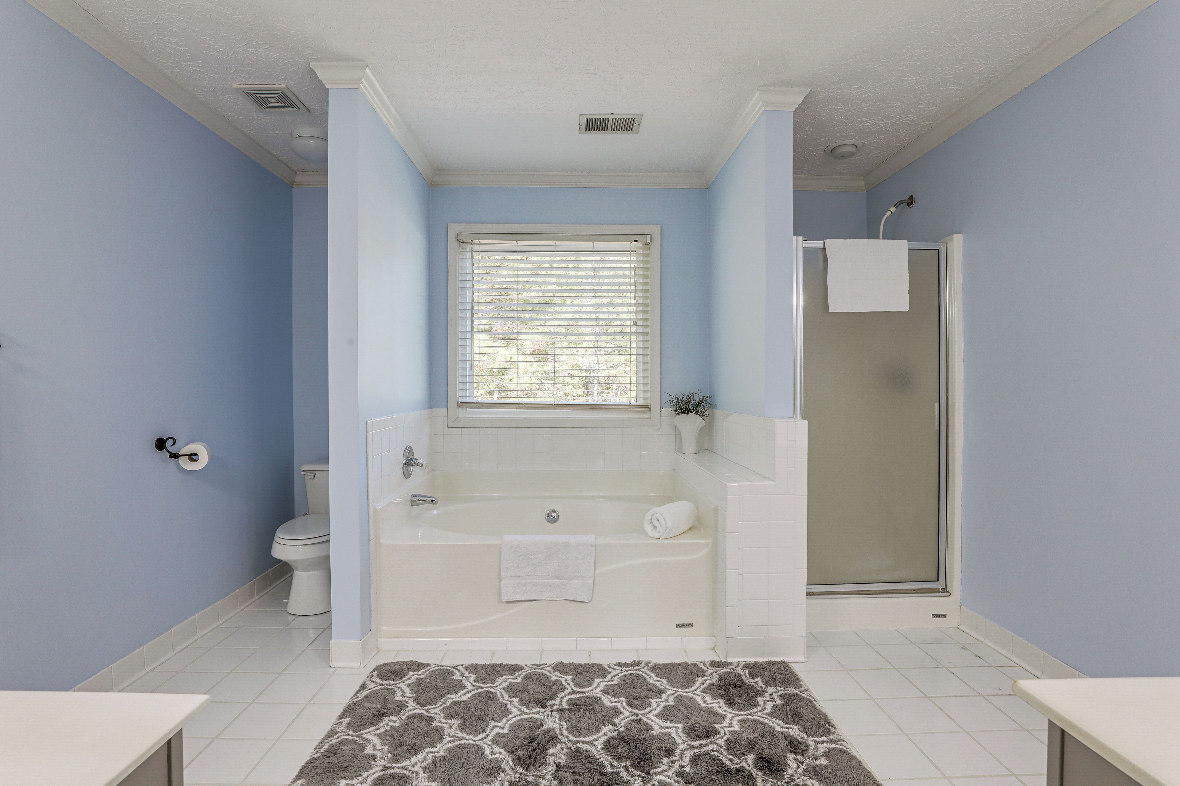 A bathroom with a bathtub, toilet, and shower.