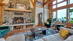 A cozy living room with a stone fireplace, wooden beams, a large window, and comfortable seating. - Big Groups Welcome! Mtn-view Onalaska Estate (Onalaska)